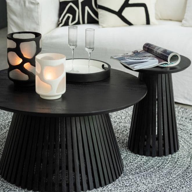 Bijzettafel Vincent van J-Line naast de zwarte salontafel, gestyled met kaarsen en een tijdschrift