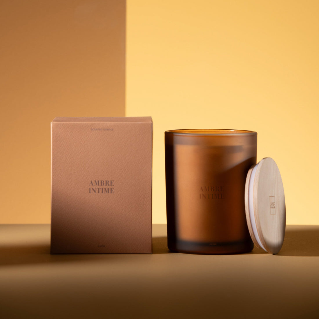 Geurkaars Accords Essentiels Ambre Intime 52 Uur van J-Line met bijpassende doos in een sfeervolle okerkleurige setting