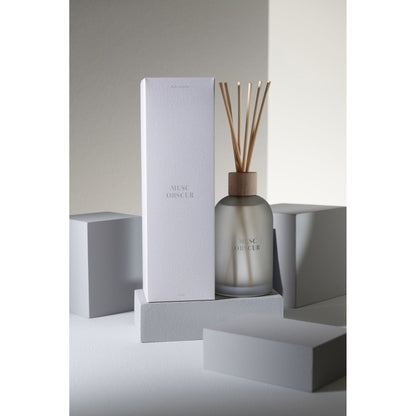 Geurstokjes Accords Essentiels Musc Obscur 250ml van J-Line op decoratieve blokken in een warme sfeerfoto