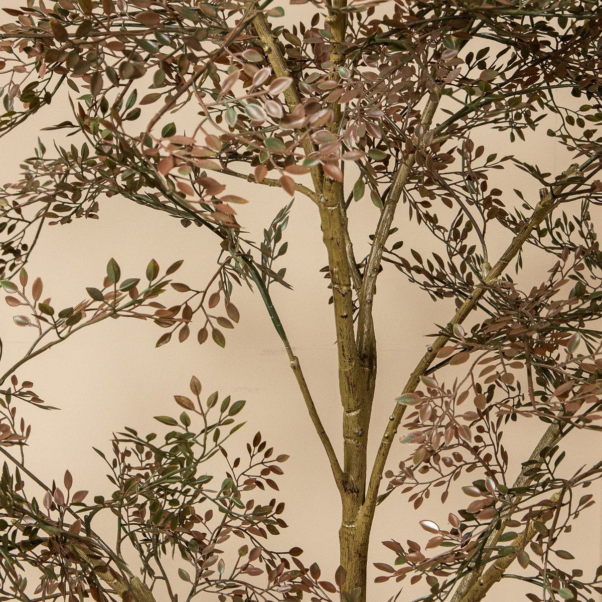 Groene kunstboom van PTMD als accent naast een kast